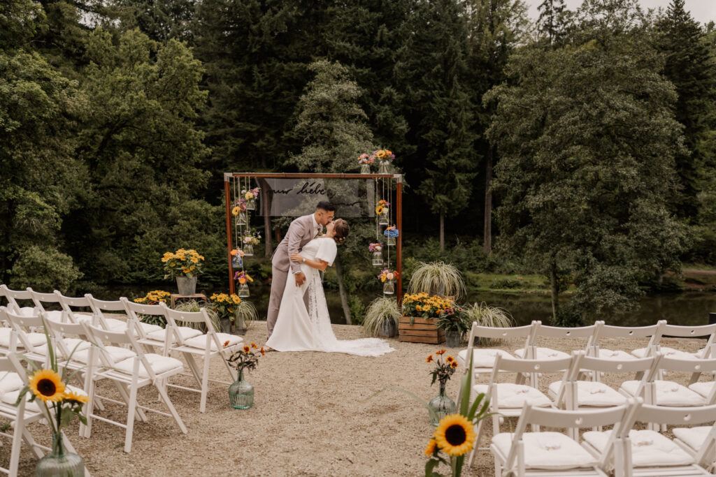 Bohemian-Hochzeitsdekoration unter Bäumen mit Makramee und Trockenblumen im Saarland