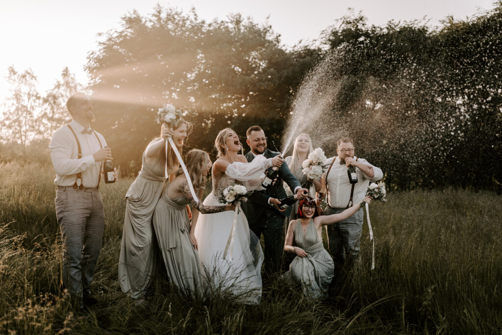 Hochzeitsgesellschaft spritzt mit Champagner im Wald im Saarland