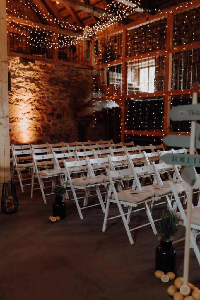 Rustikale Hochzeitslocation im Saarland mit Boho-Dekoration, Lichterketten und Blumenkränzen